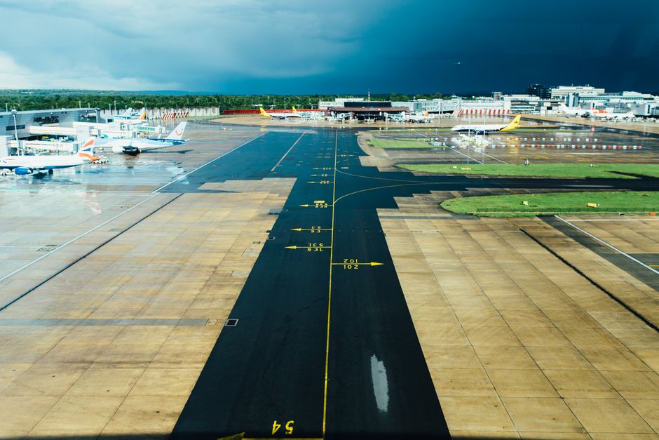 Passengers waiting at a German airport with a delayed flight board