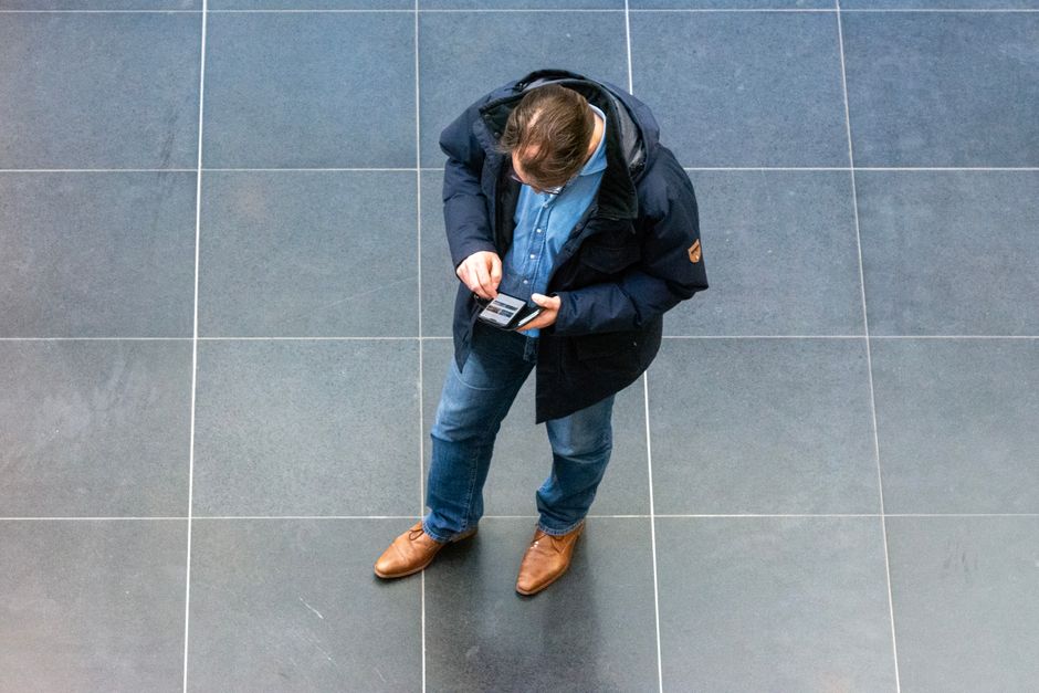 Tourist using smartphone in a German city square, connecting to internet
