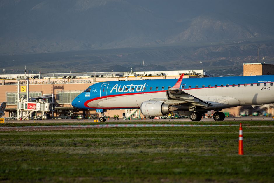 Traveler looking at a departure board at an airport in Argentina, indicating a delayed or canceled flight