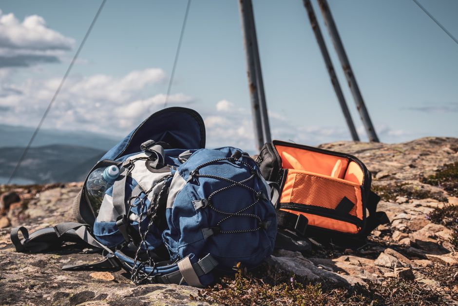 Traveler organizing a backpack with clothes for a trip to Argentina, featuring diverse climate gear.