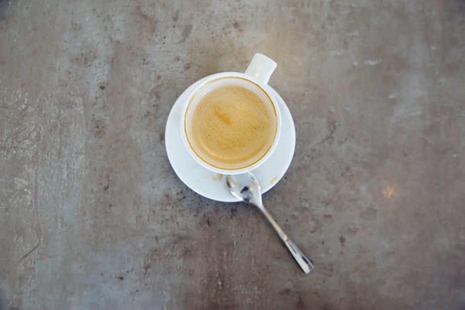 A perfectly crafted flat white coffee on a wooden table in a vibrant Australian cafe