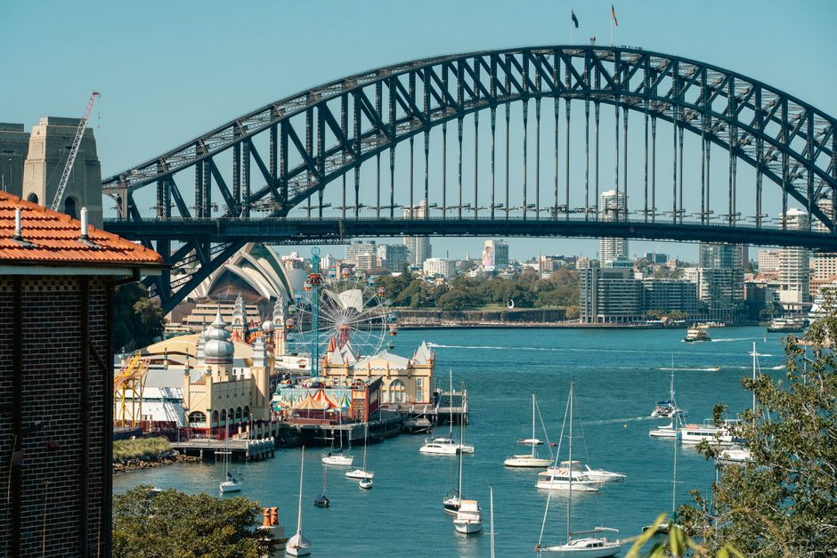 People climbing the Sydney Harbour Bridge in Australia at sunset