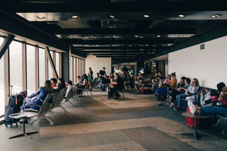 Passengers waiting in a modern airport terminal in Austria, indicating a flight delay
