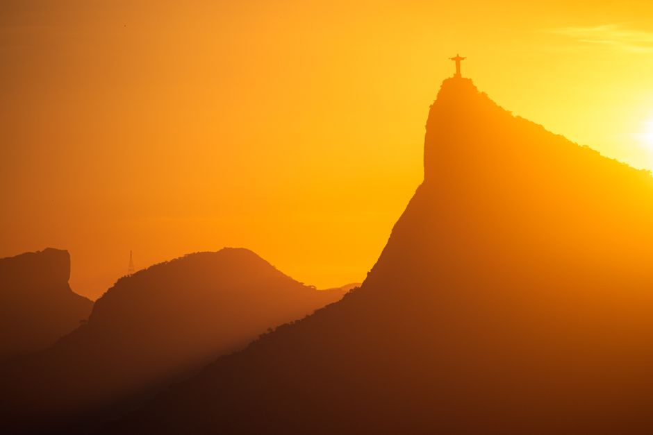 Panoramic view of Rio de Janeiro, Brazil, with Christ the Redeemer statue and Sugarloaf Mountain at sunset