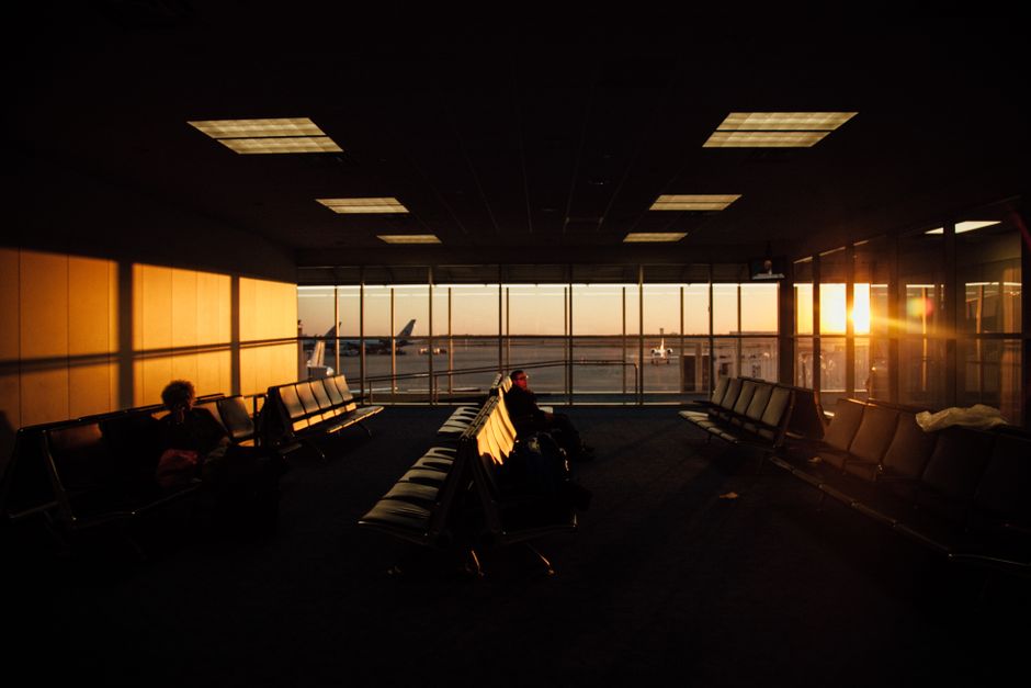 Passengers in a modern airport terminal in Canada, looking at departure boards