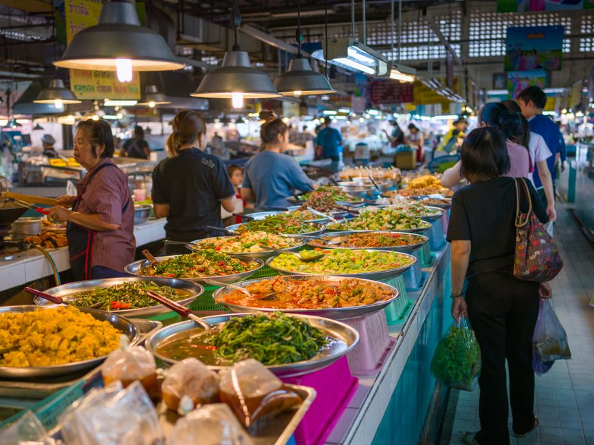 A vibrant spread of diverse Canadian food, including poutine, maple syrup, and fresh produce from a market.