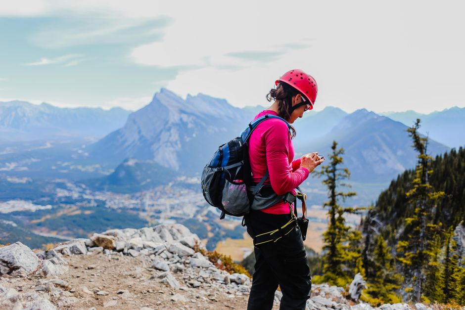 Traveler using a smartphone to access internet in a beautiful Canadian landscape