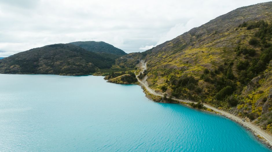 A car driving on a scenic road through the mountains of Chilean Patagonia