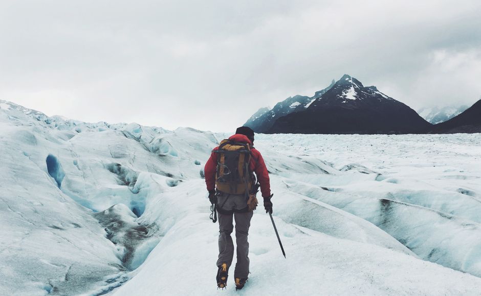 Traveler packing a backpack in front of stunning Chilean mountains, ready for adventure