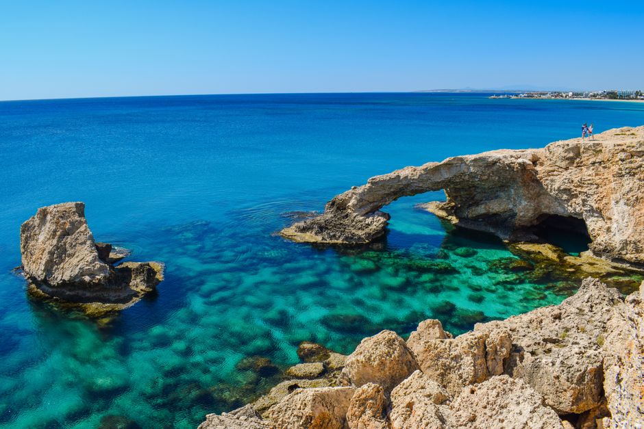 Car driving along a scenic coastal road in Cyprus with blue sea