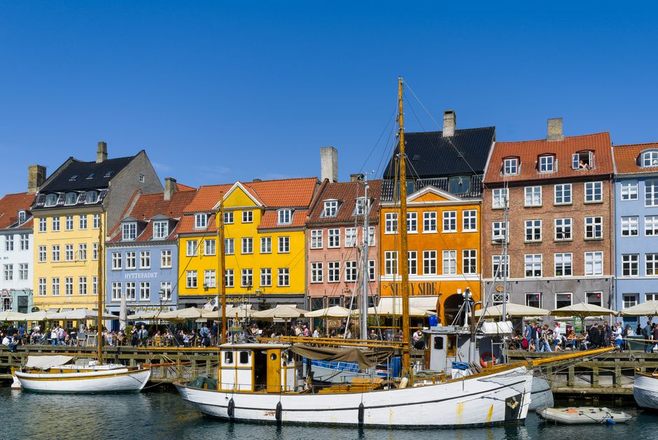 Traveler using a smartphone in the colorful Nyhavn harbor in Copenhagen, Denmark