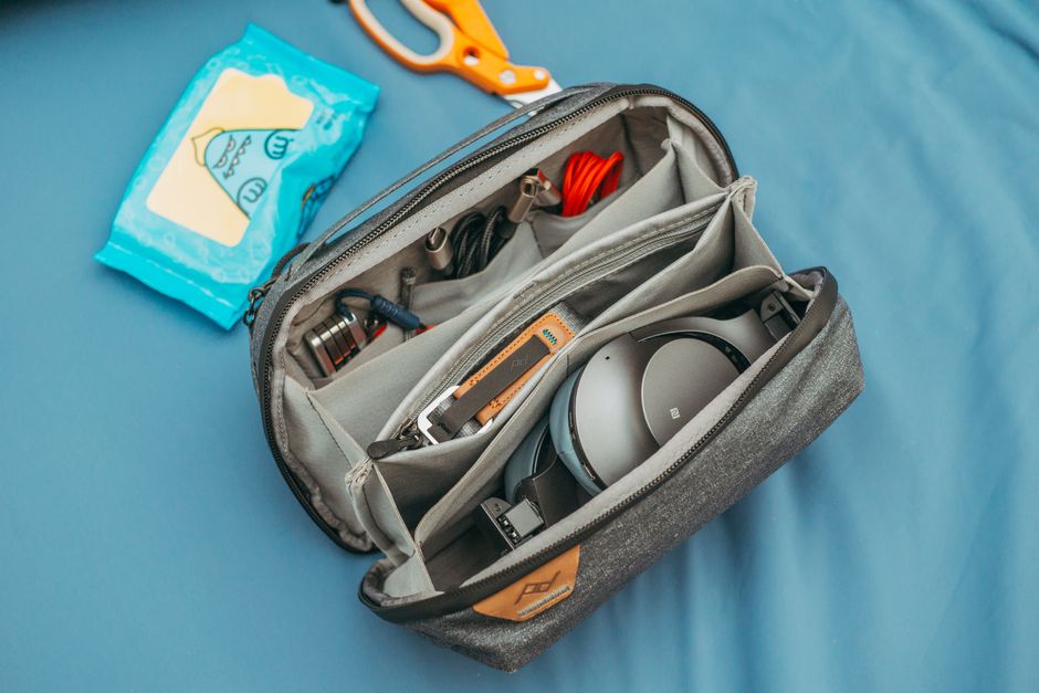 A flat lay of essential items for a trip to Denmark, including a power adapter, waterproof jacket, and walking shoes