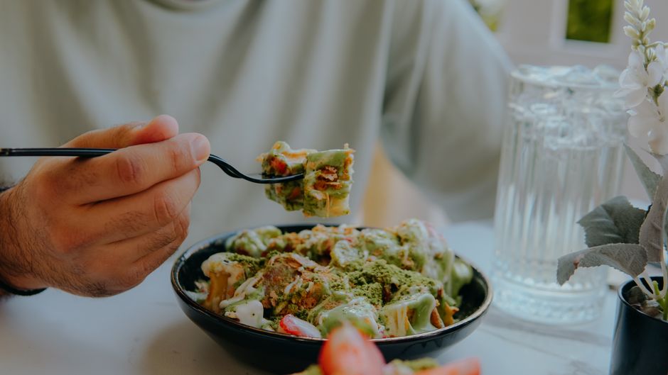 A vibrant plate of Koshary, a traditional Egyptian street food, in a bustling market in Egypt.