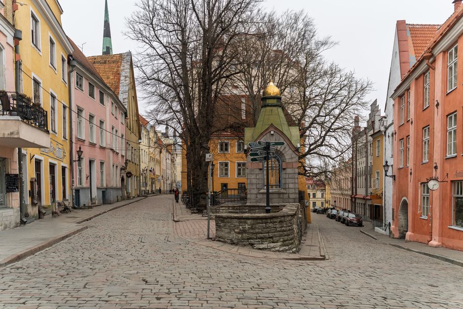 Historic Old Town street in Tallinn, Estonia, bustling with visitors and cafes