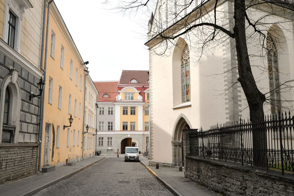 Traveler using a smartphone in a modern city square in Tallinn, Estonia, accessing fast internet.