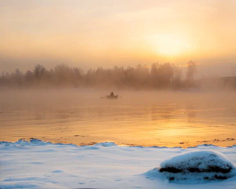 Traditional Finnish mökki cottage by a serene lake at sunset in Finland
