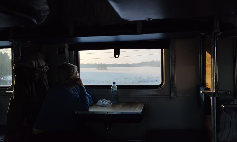 Scenic winter landscape in Finland with a train passing through, heading towards Lapland