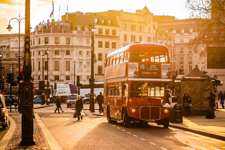 Iconic red double-decker bus passing Big Ben in London, Great Britain