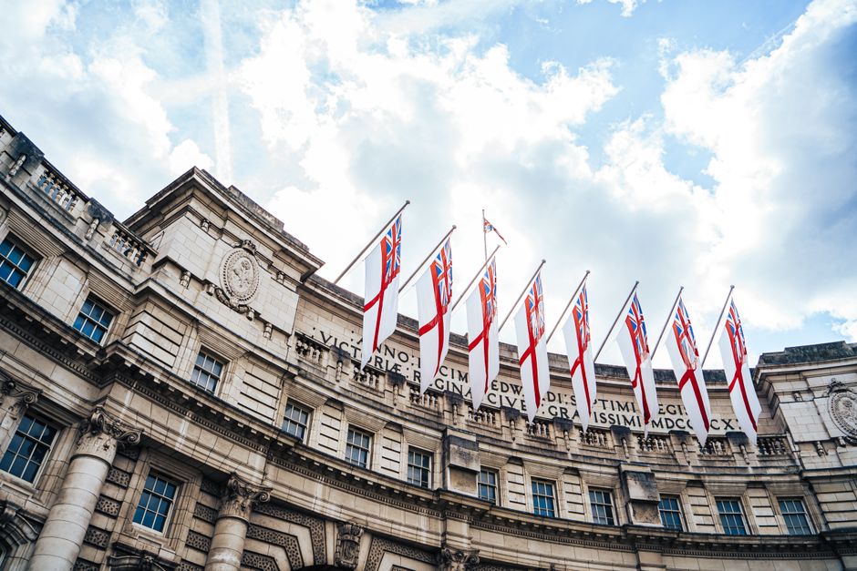 Modern hotel exterior in central London, Great Britain, with a classic red bus passing by.