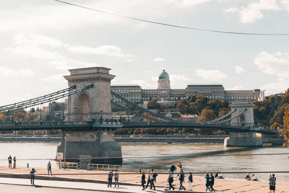 Traveler using a smartphone with Budapest cityscape in the background, symbolizing internet connectivity in Hungary