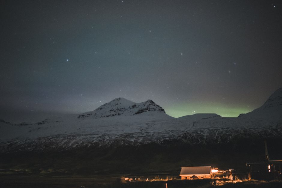 Cozy guesthouse in Iceland with northern lights visible in the sky