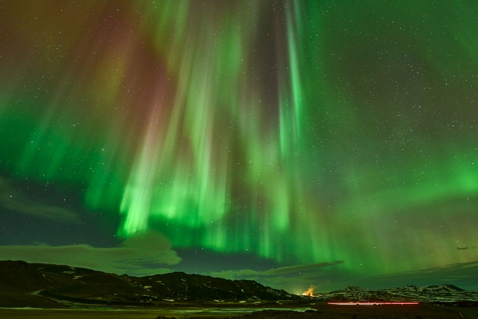 Traveler connecting to internet under aurora borealis in Iceland