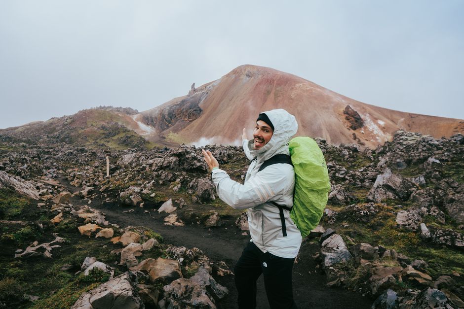 Traveler in waterproof gear hiking through a stunning Icelandic landscape