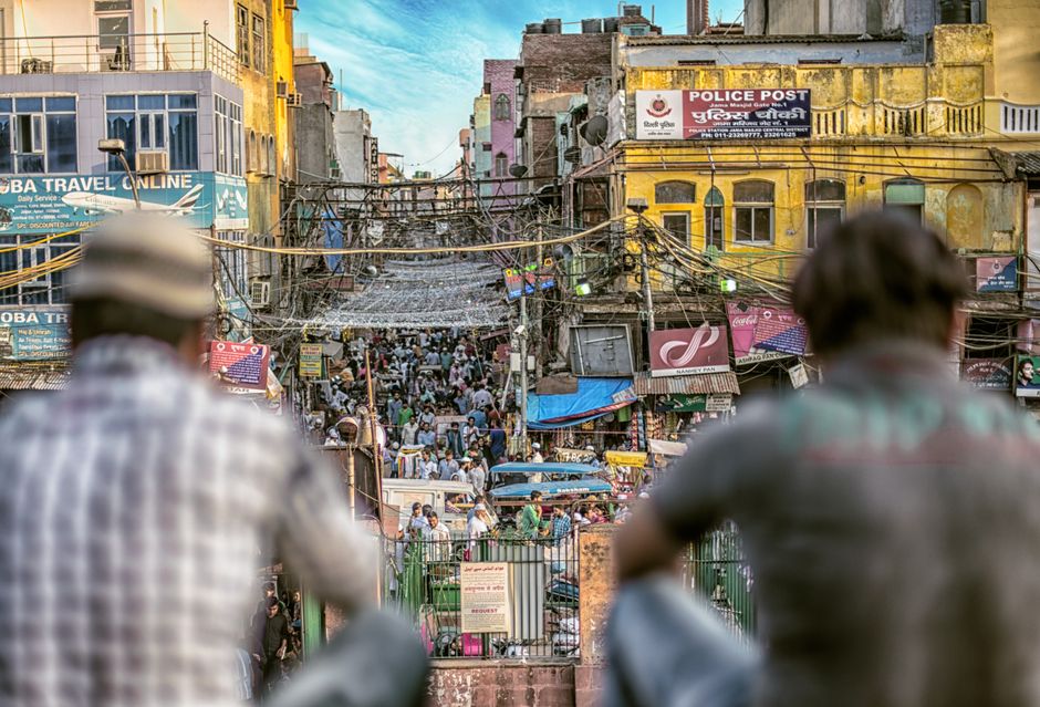 Budget traveler navigating a bustling market street in India, showcasing affordable travel