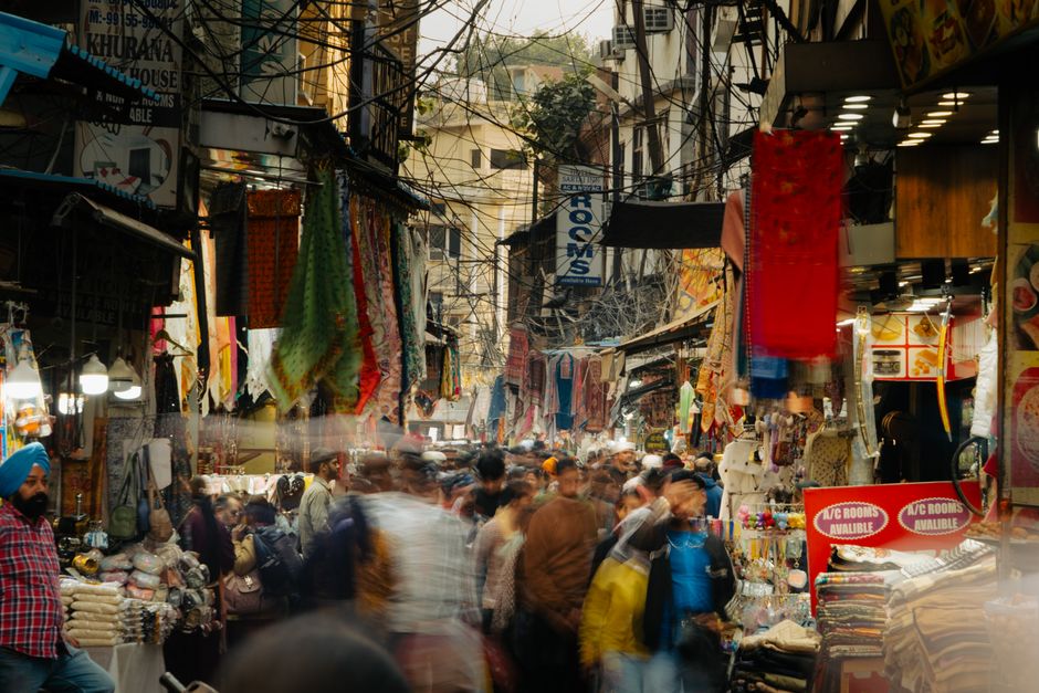 Traveler consulting a map in a bustling Indian market, symbolizing preparation for a trip to India