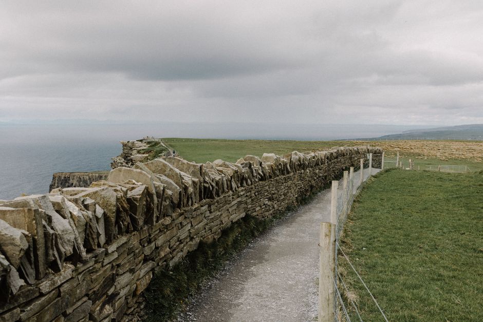 Rolling green hills of Ireland under a partly cloudy sky, showcasing the country's changeable weather
