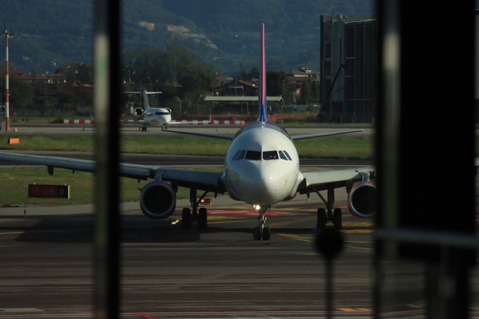 Passengers waiting in a modern airport terminal in Italy due to a delayed flight