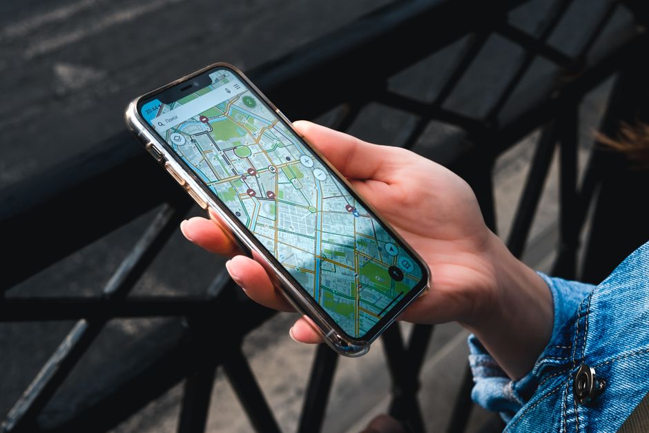 Traveler using a smartphone with a map of Italy for navigation