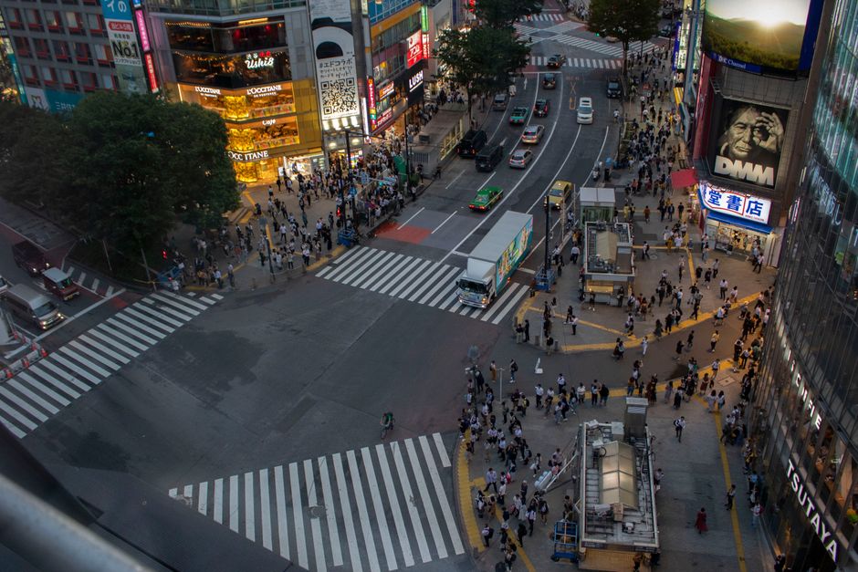 Vibrant Shibuya crossing in Tokyo, Japan, bustling with people and neon lights