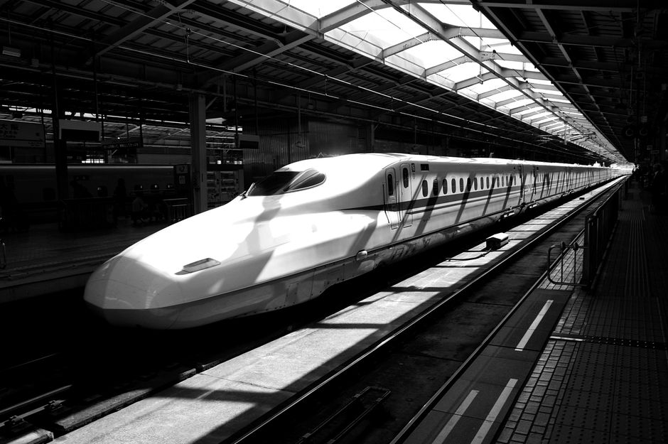 A Shinkansen bullet train speeding through the Japanese countryside with Mount Fuji in the background