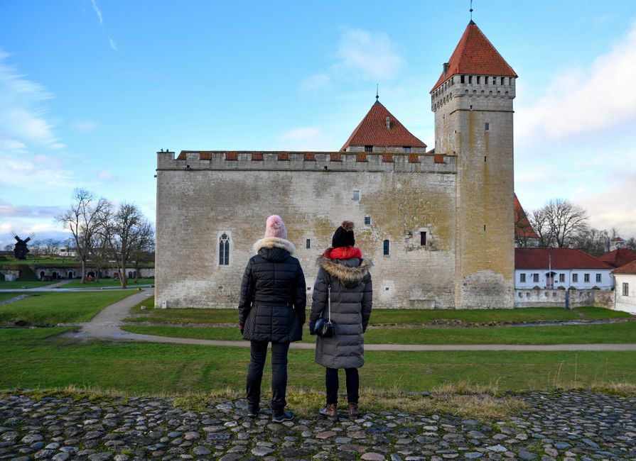 Cēsis Castle complex in Latvia, a medieval fortress surrounded by autumn foliage.