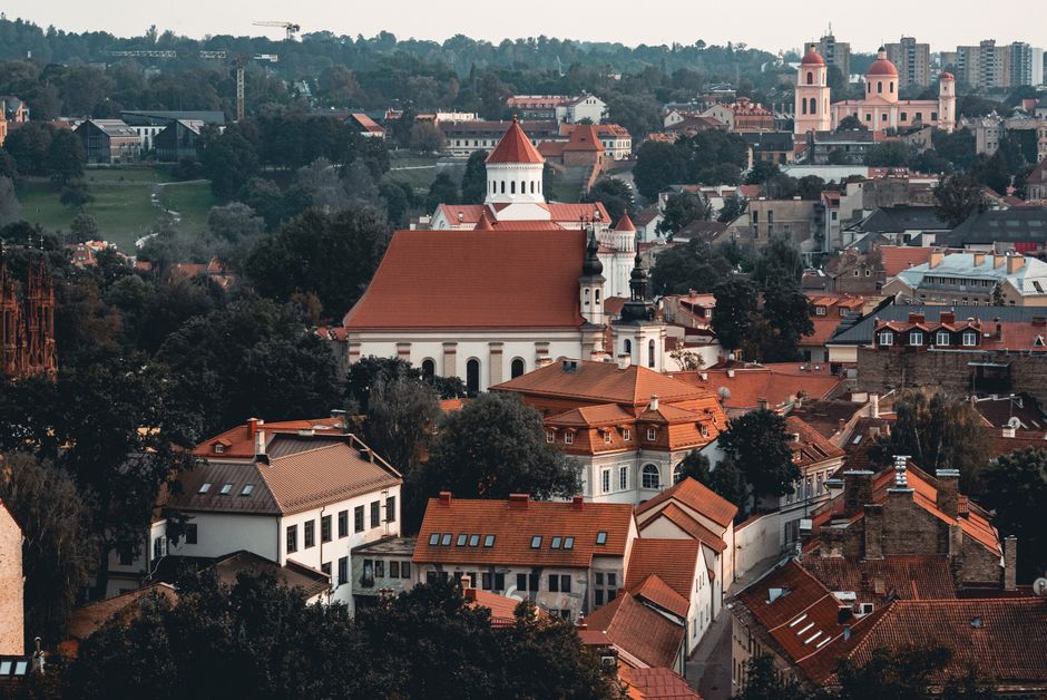 Lively street scene in Vilnius Old Town, Lithuania, with historic buildings and people enjoying the atmosphere