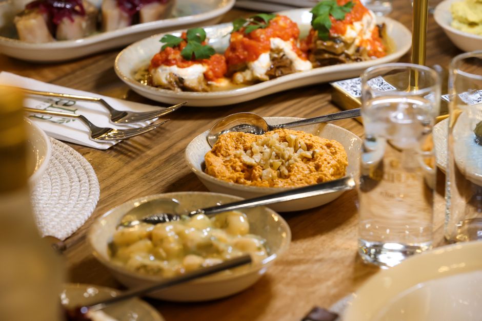 A vibrant spread of traditional Lithuanian dishes including Cepelinai and Šaltibarščiai on a wooden table.