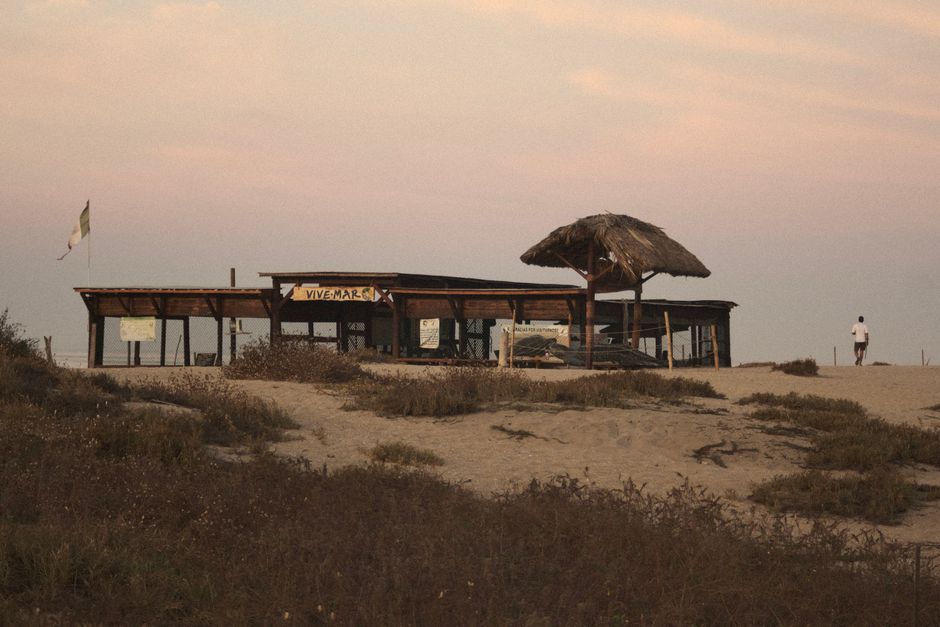 Traveler relaxing on a beach in Mexico with a travel insurance policy document