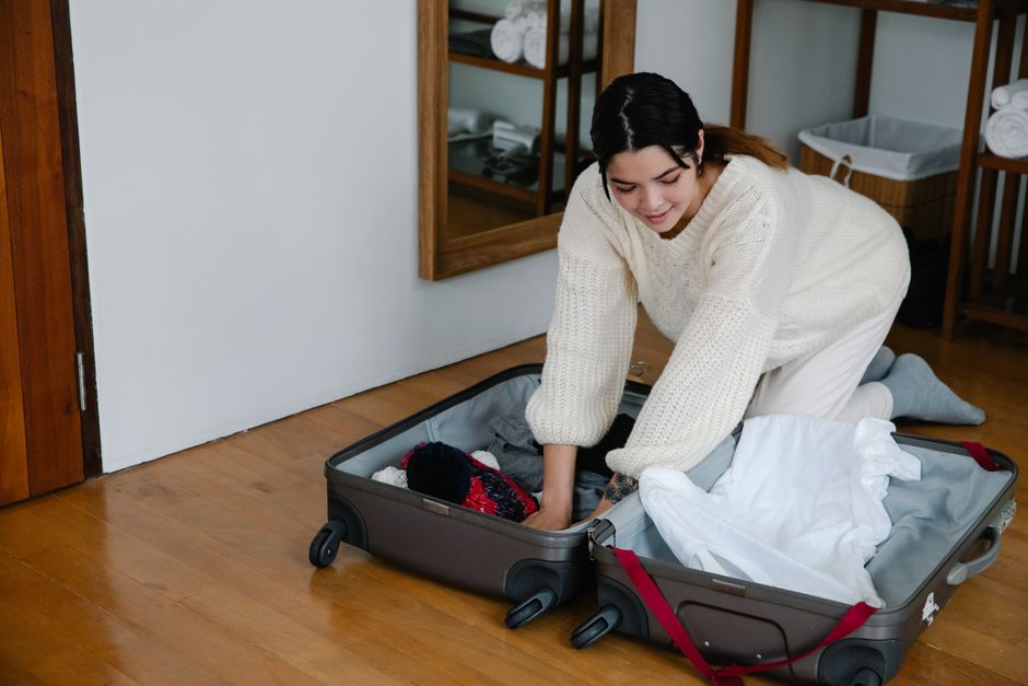 A person packing a suitcase with clothes suitable for travel in Moldova, ready for adventure