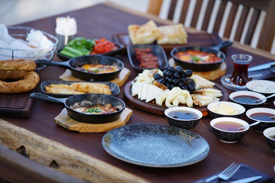 A vibrant spread of traditional Montenegrin dishes, including cured ham, cheese, and olives, set on a rustic table.