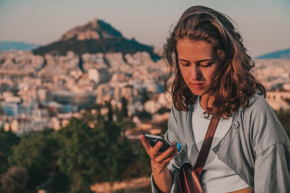 Tourist checking phone with beautiful Bay of Kotor in Montenegro