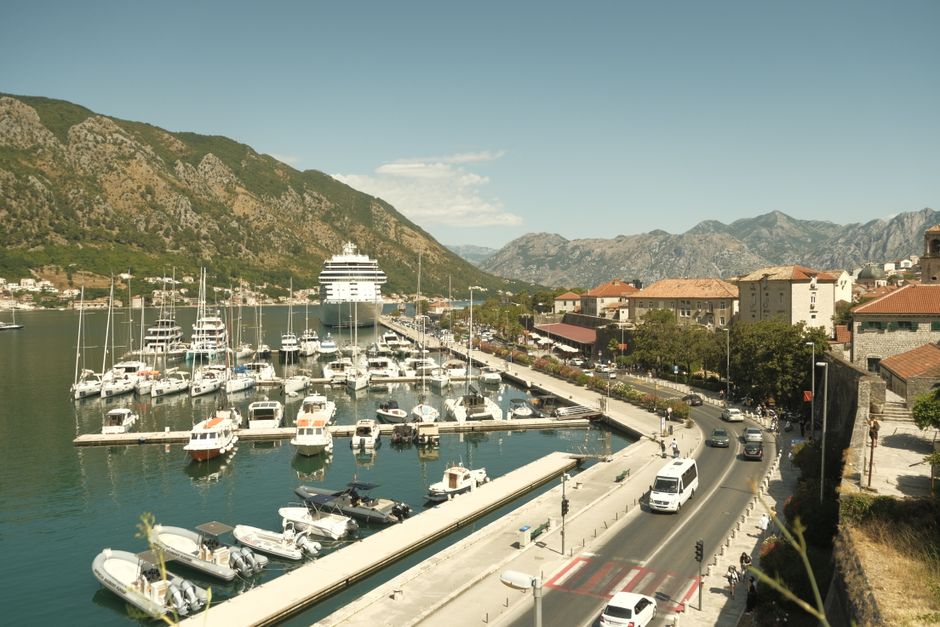 A car driving along a scenic coastal road in Montenegro, illustrating easy transfers