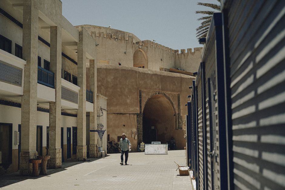 Tourist happily using a smartphone in a vibrant Moroccan medina, staying connected