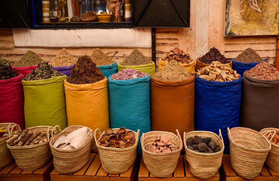 Vibrant Moroccan souk with colorful goods and people, representing travel budgeting and experiences in Morocco