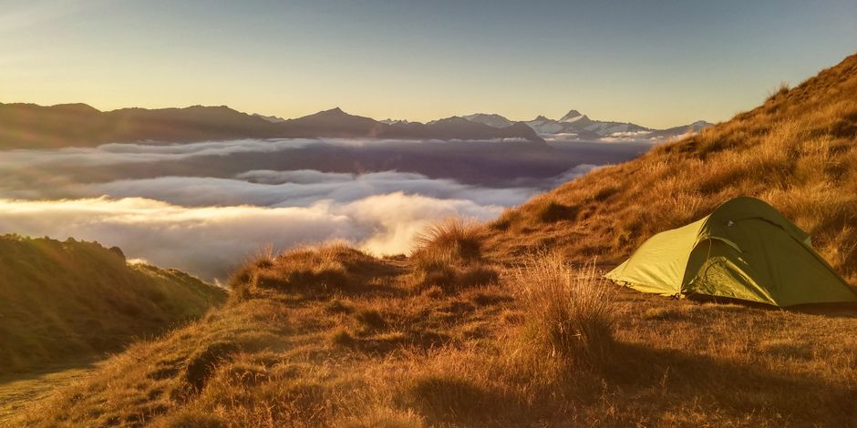 Backpacker enjoying a scenic view in New Zealand, symbolizing affordable travel