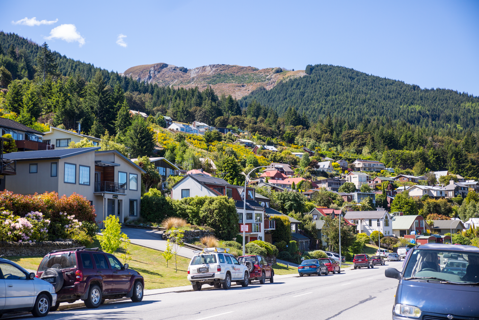 Diverse transport options in New Zealand, including a bus, ferry, and car on a scenic road