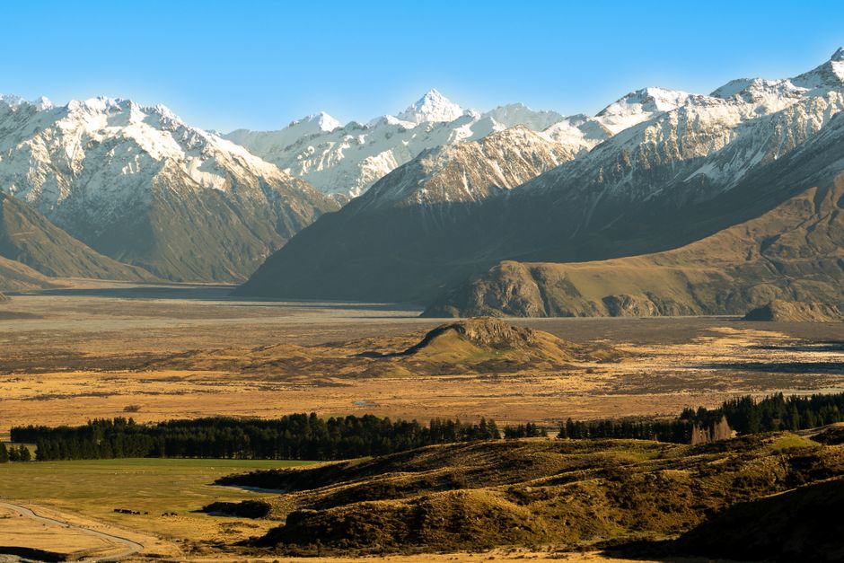 Happy travelers exploring a stunning New Zealand landscape, protected by travel insurance