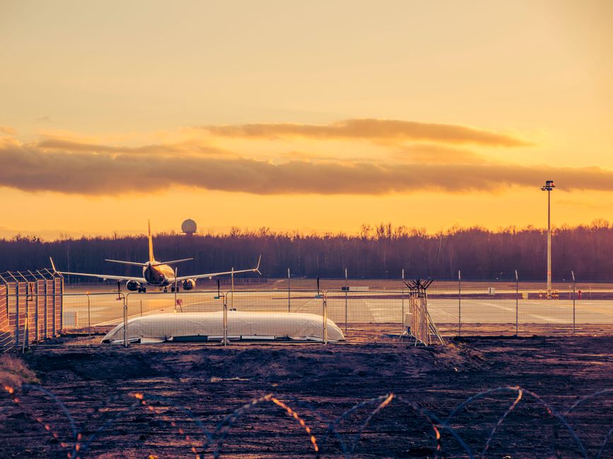 Modern terminal building at Warsaw Chopin Airport in Poland with planes on the tarmac.