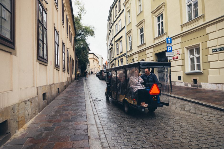 Tourist using a digital map on a smartphone in Krakow, Poland, with historic buildings in the background