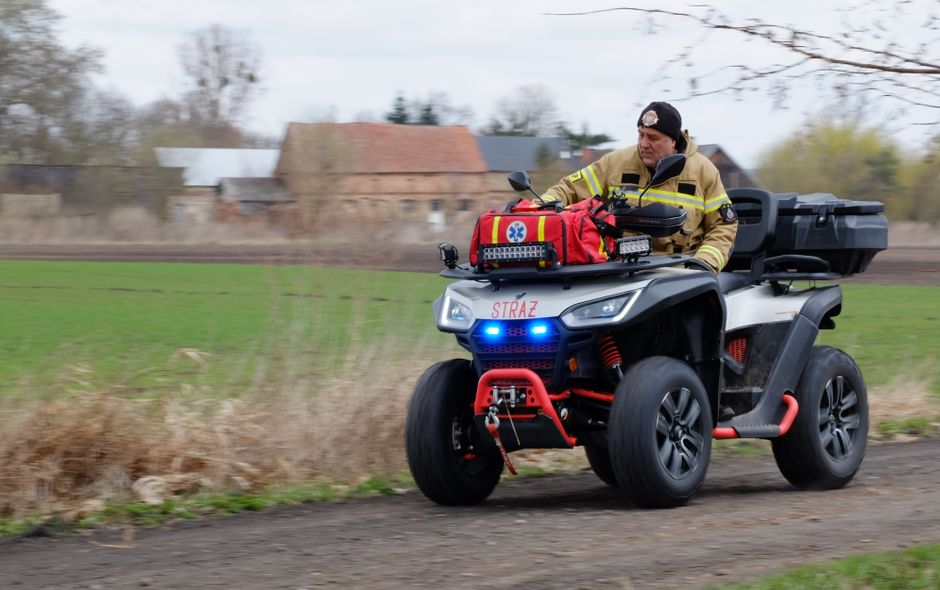 Emergency vehicles in Poland, including police, fire, and ambulance, with a Polish flag in the background
